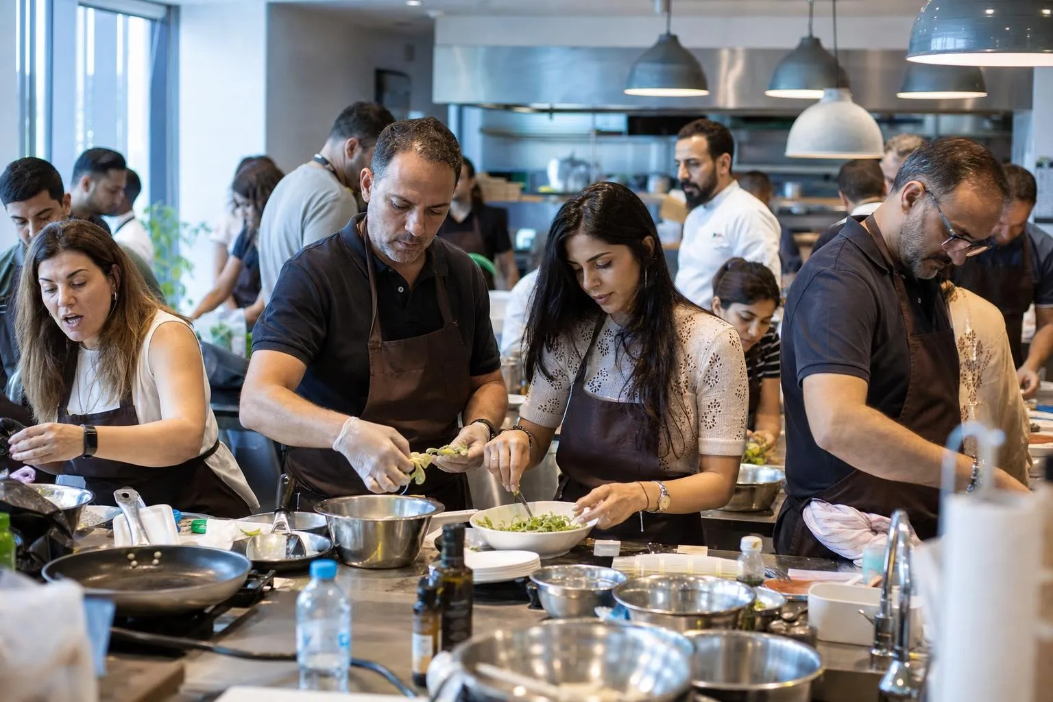 A team mid-programme on Chef's Table Challenge — Dubai, cooking studio or hotel training kitchen.