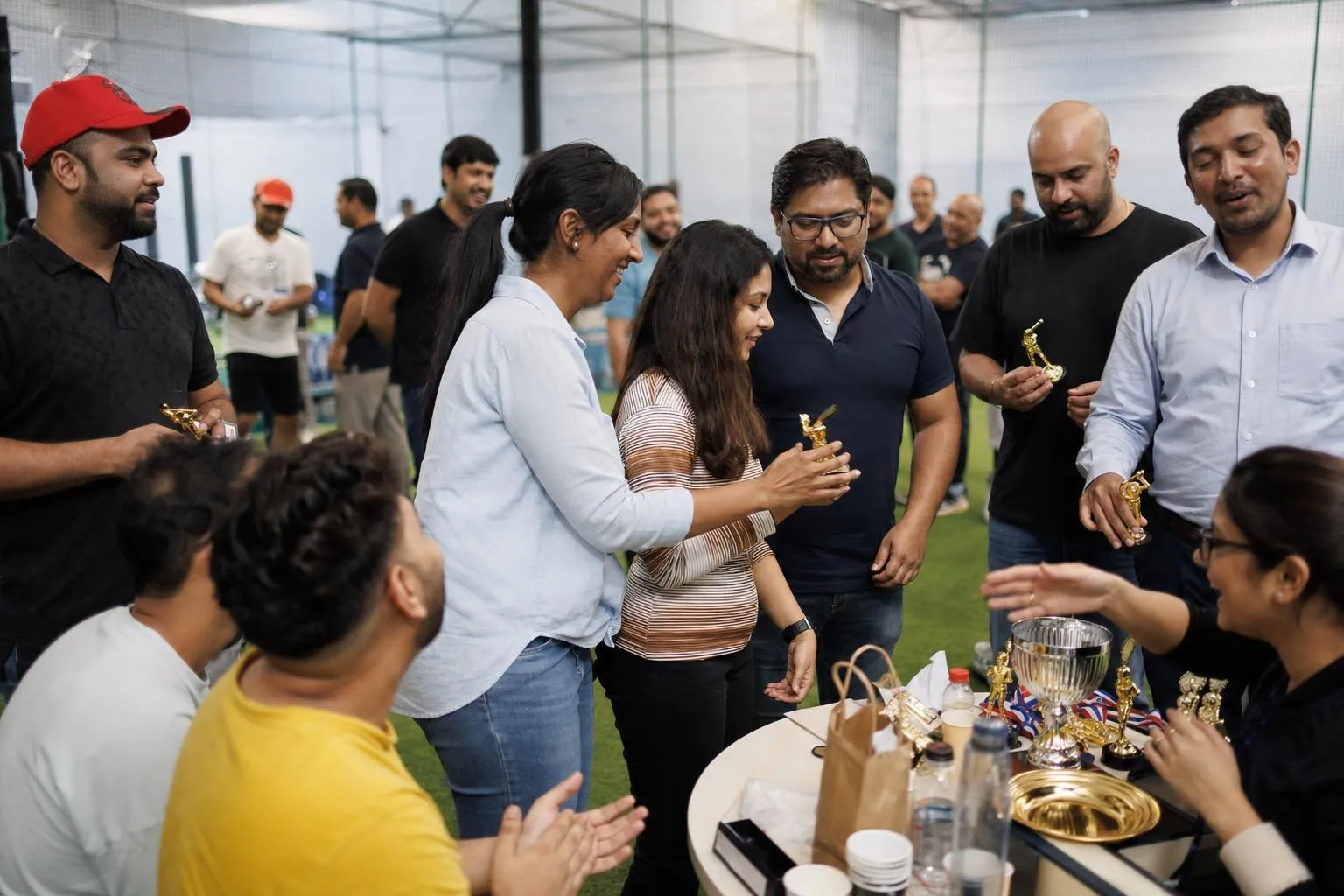 A team mid-programme on Corporate Cricket — Dubai or Sharjah, indoor cricket facility, air-conditioned.